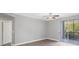 Bright living room with gray walls, ceiling fan, and sliding glass doors to the outdoor patio at 5691 Bentgrass Dr # 15-101, Sarasota, FL 34235