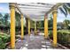 Relaxing outdoor lounge area featuring a covered pergola with bright yellow columns, offering a perfect spot for community gatherings at 5691 Bentgrass Dr # 15-101, Sarasota, FL 34235