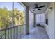 The screened-in patio is shaded and features a ceiling fan and trees at 5691 Bentgrass Dr # 15-101, Sarasota, FL 34235