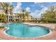 Community pool surrounded by palm trees and lounge chairs, perfect for residents to enjoy a refreshing swim at 5691 Bentgrass Dr # 15-101, Sarasota, FL 34235