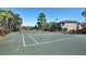 Well-maintained tennis court surrounded by trees and fencing, ready for a competitive match at 5691 Bentgrass Dr # 15-101, Sarasota, FL 34235