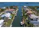 Aerial view of a waterfront neighborhood with luxurious homes, private docks, and boats along a scenic canal at 581 Kingfisher Ln, Longboat Key, FL 34228