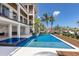 View of backyard featuring a pool, dining, outdoor kitchen, and a waterfront canal under a bright blue sky at 581 Kingfisher Ln, Longboat Key, FL 34228