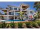 Beautiful shot of a modern three-story home's backyard featuring a pool, lounge chairs, and palm trees under a clear sky at 581 Kingfisher Ln, Longboat Key, FL 34228