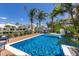 View of backyard featuring a pool, lounge chairs, and a waterfront canal with luxury homes under a bright blue sky at 581 Kingfisher Ln, Longboat Key, FL 34228