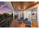 Expansive balcony with wood ceiling, comfortable seating, and panoramic waterfront views at sunset at 581 Kingfisher Ln, Longboat Key, FL 34228