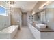 Modern bathroom with a dual sink vanity, soaking tub, and separate glass-enclosed shower at 581 Kingfisher Ln, Longboat Key, FL 34228