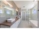 Modern bathroom featuring dual sinks, a large mirror, and a glass-enclosed shower and bathtub at 581 Kingfisher Ln, Longboat Key, FL 34228