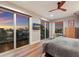 Bright bedroom with multiple sliding glass doors overlooking a waterfront view at sunset at 581 Kingfisher Ln, Longboat Key, FL 34228