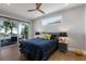 Bedroom with a ceiling fan, balcony access, and views of palm trees at 581 Kingfisher Ln, Longboat Key, FL 34228