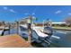 Boat on lift at private dock, providing easy access for boating and watersports enthusiasts with waterfront living at 581 Kingfisher Ln, Longboat Key, FL 34228