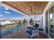 Spacious covered deck with stylish seating, wood ceiling, and waterfront views at 581 Kingfisher Ln, Longboat Key, FL 34228