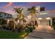 Contemporary home with mature palm trees, manicured landscaping, and well-lit driveway and covered parking at 581 Kingfisher Ln, Longboat Key, FL 34228