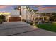 Modern home showcasing an oversized driveway, meticulous landscaping, and a two-car garage with rich wood accents at 581 Kingfisher Ln, Longboat Key, FL 34228