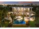 Expansive multi-level home with balconies, swimming pool, lush landscaping, and water views at 581 Kingfisher Ln, Longboat Key, FL 34228