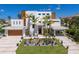 Stunning modern home with lush landscaping, a two-car garage, and a covered parking area, embodying luxury living at 581 Kingfisher Ln, Longboat Key, FL 34228