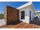 Exterior of modern home showcasing wood and white accents and a private deck at 581 Kingfisher Ln, Longboat Key, FL 34228