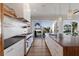 Bright kitchen featuring a spacious island, stainless steel appliances, and sliding glass doors to the backyard at 581 Kingfisher Ln, Longboat Key, FL 34228