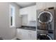 This laundry room features a modern washer/dryer set, sink, and cabinets for convenient storage at 581 Kingfisher Ln, Longboat Key, FL 34228