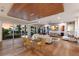Open-concept living room with floor-to-ceiling windows, hardwood floors, and a modern dining area with water views at 581 Kingfisher Ln, Longboat Key, FL 34228