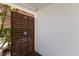 This outdoor shower features a slatted wood privacy screen and a modern shower fixture against a stark white wall at 581 Kingfisher Ln, Longboat Key, FL 34228