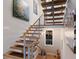 Modern staircase featuring wood treads, sleek metal railings, and stylish artwork enhancing the contemporary design at 581 Kingfisher Ln, Longboat Key, FL 34228