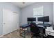Office area featuring a desk, two monitors, and a printer, with wood-look floors and natural light at 5861 Bungalow Grove Ct, Palmetto, FL 34221