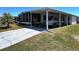Charming single-story home with a driveway, carport, and screened lanai, surrounded by a well-maintained lawn at 606 Cyprus Ct, Bradenton, FL 34207