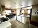Open kitchen with white cabinetry, breakfast bar, and tile flooring, flowing into a dining and living area at 606 Cyprus Ct, Bradenton, FL 34207