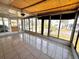 Bright sunroom features tiled floors, ceiling fan, and many windows for natural light and views at 606 Cyprus Ct, Bradenton, FL 34207