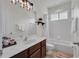 Bright bathroom featuring a white vanity with dark wood accents, a mirror, and a shower-tub combo at 6106 34Th E Ct, Ellenton, FL 34222