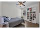 Cozy bedroom with a ceiling fan, a comfortable bed with pillows, a window, and a bookshelf with books at 6106 34Th E Ct, Ellenton, FL 34222