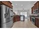 View of the kitchen with stainless steel refrigerator and range, wood cabinets, and open flow to living space at 6106 34Th E Ct, Ellenton, FL 34222