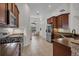 Modern kitchen with stainless appliances, granite countertops, and warm wood cabinetry, adjacent to a dining area at 6106 34Th E Ct, Ellenton, FL 34222
