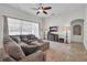 Comfortable living room features tile floors, a ceiling fan, and a plush couch with natural light from the window at 6106 34Th E Ct, Ellenton, FL 34222