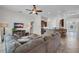 Spacious living area with tile flooring, a ceiling fan, a comfy couch, and an open view to the kitchen at 6106 34Th E Ct, Ellenton, FL 34222