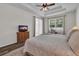 Main bedroom featuring a decorative ceiling, wood-look floors, television, and natural light from windows at 6106 34Th E Ct, Ellenton, FL 34222