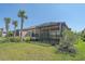 Screened patio with tropical landscaping including palm trees and lush green grass at 6120 Plateau Ct, Bradenton, FL 34203
