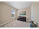 A bedroom with carpeted flooring, natural light from the window, and a black futon at 6120 Plateau Ct, Bradenton, FL 34203