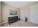 A bedroom with carpet flooring, an accent painting, and a black futon at 6120 Plateau Ct, Bradenton, FL 34203