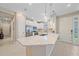 Bright kitchen features a large island, pendant lighting, stainless steel appliances, and white cabinetry at 6120 Plateau Ct, Bradenton, FL 34203