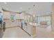 Open-concept kitchen with white cabinets, stainless appliances, large island and view of the living room at 6120 Plateau Ct, Bradenton, FL 34203