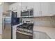 Updated kitchen showcasing stainless steel appliances, white cabinetry, and stone countertops at 6120 Plateau Ct, Bradenton, FL 34203