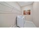 Well-lit laundry room with washer, dryer, wire shelving and neutral paint at 6120 Plateau Ct, Bradenton, FL 34203