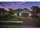 Charming home featuring a lush, landscaped front yard, brick paver driveway, and two-car garage at 6266 Mesa Gln, Bradenton, FL 34203