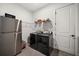Well-organized laundry room with modern washer, dryer, stainless steel refrigerator, and storage shelves at 6266 Mesa Gln, Bradenton, FL 34203