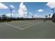 Well-maintained tennis court with palm trees and fencing, offering a recreational amenity for residents at 6266 Mesa Gln, Bradenton, FL 34203