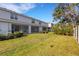 Backyard of the property with a green lawn, a line of trees, and screened in porches at 6516 Serenity Fall Ln, Sarasota, FL 34240