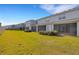 View of a lush green backyard featuring a row of screened in patios at 6516 Serenity Fall Ln, Sarasota, FL 34240