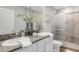 Elegant bathroom featuring double sinks, granite countertops, and a tiled walk-in shower at 6516 Serenity Fall Ln, Sarasota, FL 34240